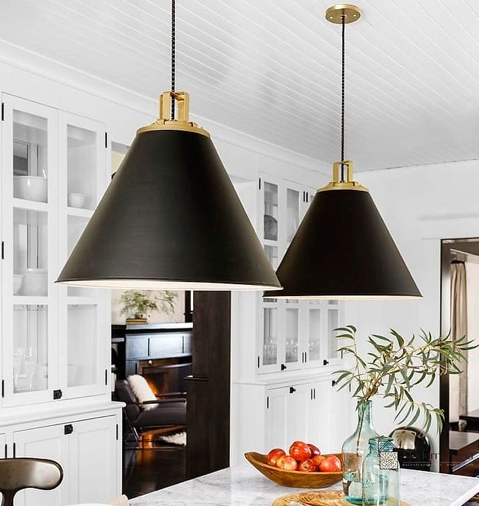 Black Pendant Lights Over a White Island