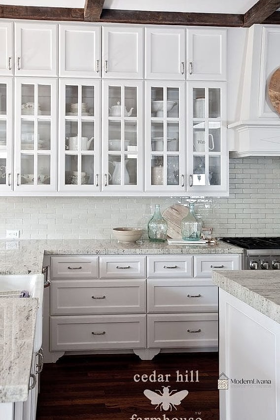 28 White Farmhouse Kitchen Ideas That Look Expensive But Aren't 19 Glass-Front Upper Cabinets